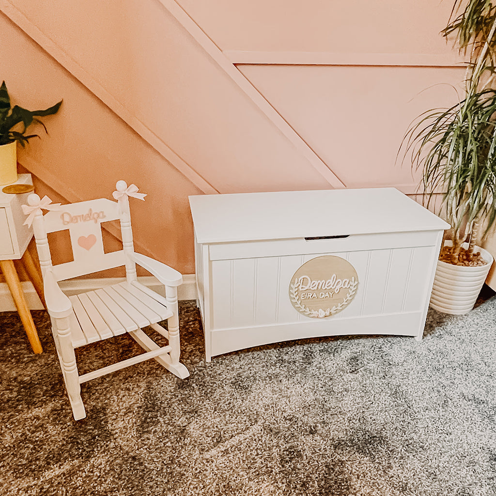 Personalised white wooden children’s rocking chair with decorative name lettering and bow