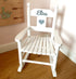 Personalised white wooden children’s rocking chair with decorative name lettering and bow