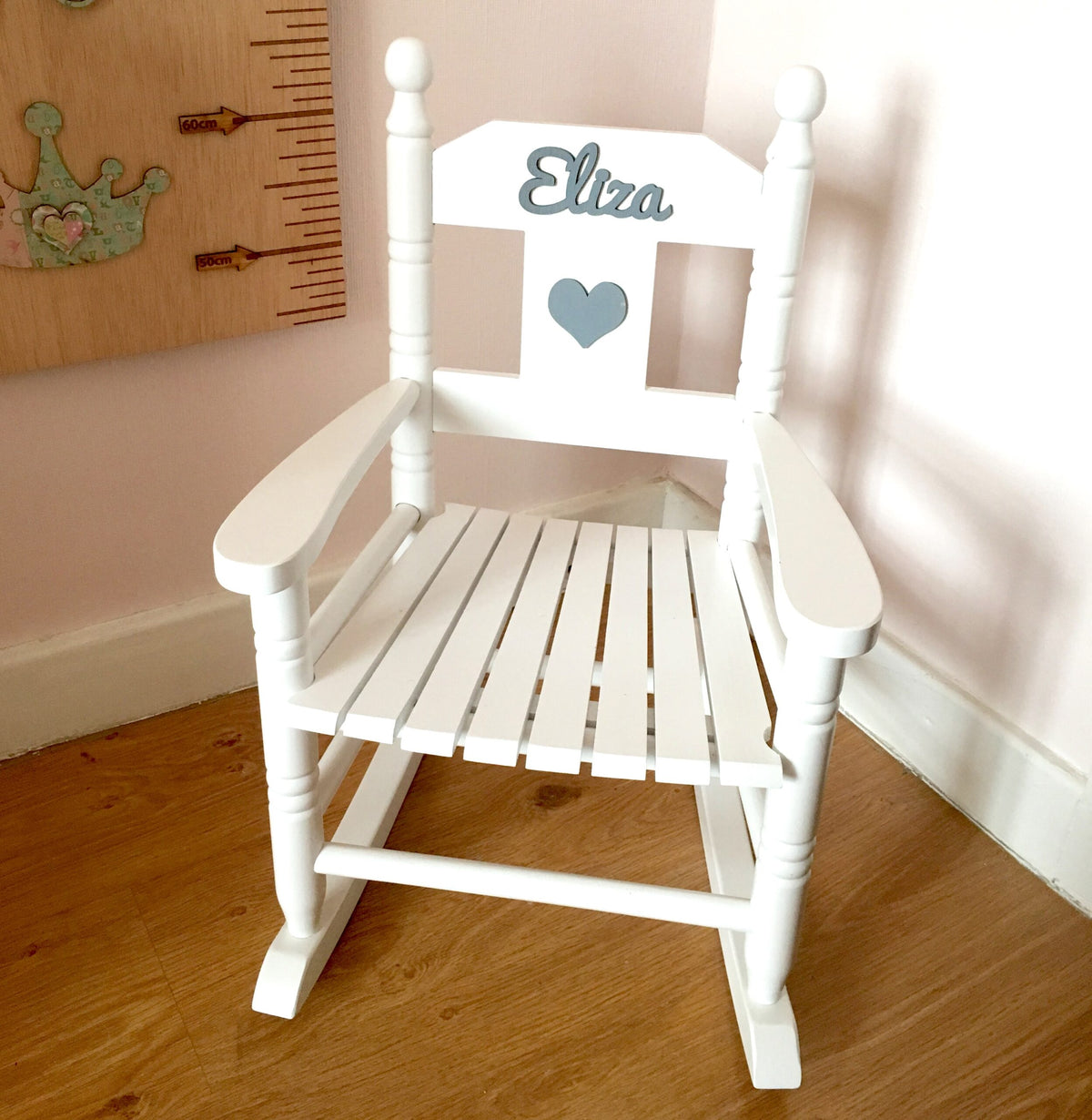Personalised white wooden children’s rocking chair with decorative name lettering and bow
