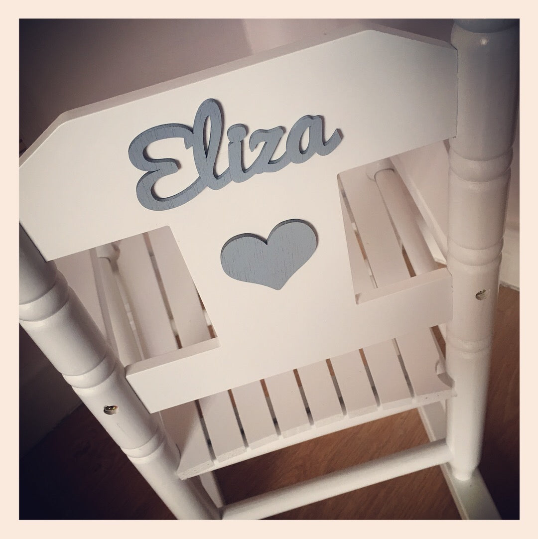 Personalised white wooden children’s rocking chair with decorative name lettering and bow