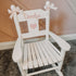 Personalised white wooden children’s rocking chair with decorative name lettering and bow