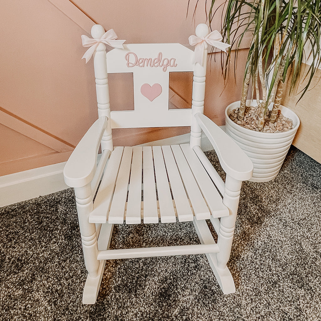 Personalised white wooden children’s rocking chair with decorative name lettering and bow