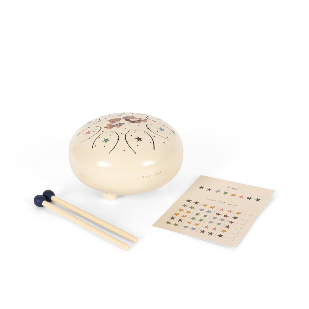 A ceramic steel pan harmonica set on a white background, including a cream-colored round harmonica decorated with floral patterns, wooden mallets with black rubber tips, and a small instruction card.
